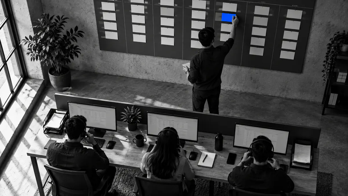 Sales team on a CRM pipeline wall of index cards, one card being moved to the next stage